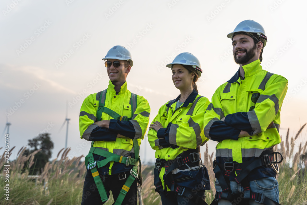Wind turbine engineer men and woman standing arm crossed in windmill farm