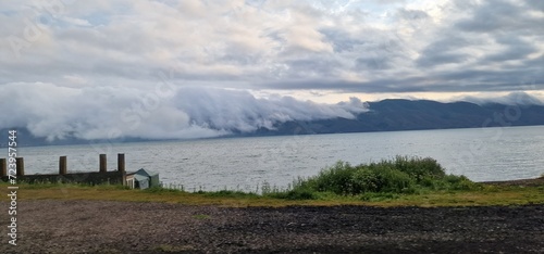 clouds falling over the meountains behind the lake Sevan in Armenia photo