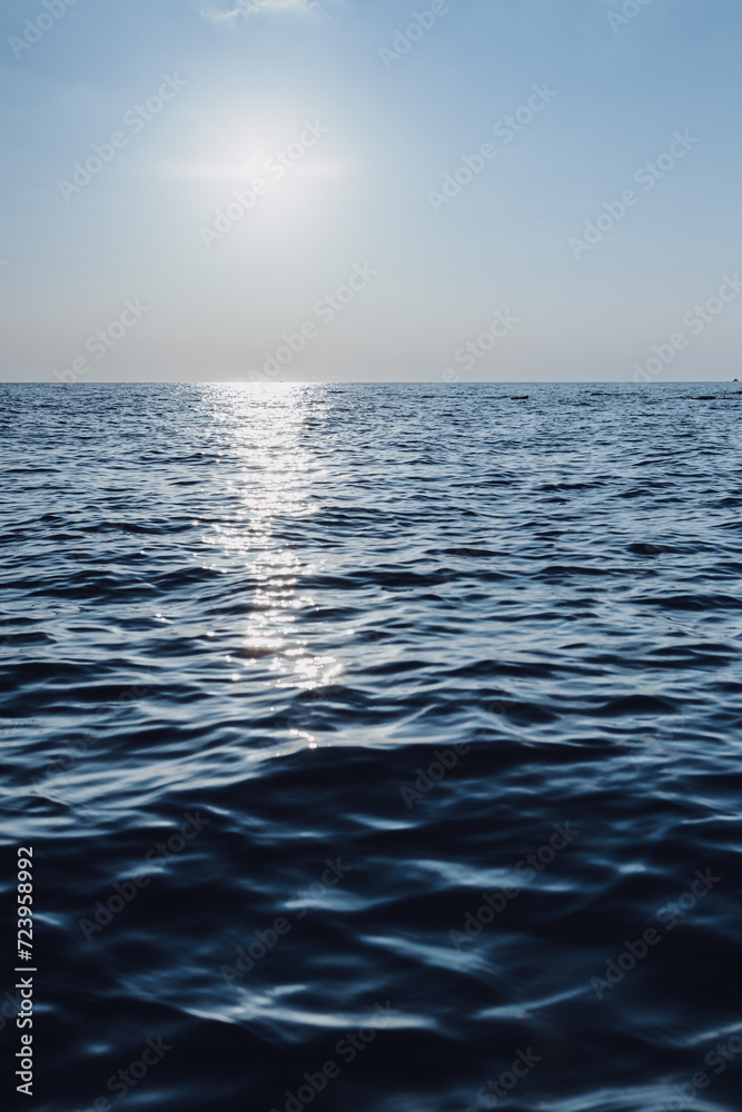 beautiful seascape. The blue sea goes into the horizon. reflection of the sun in the sea.vertical photo of the sea