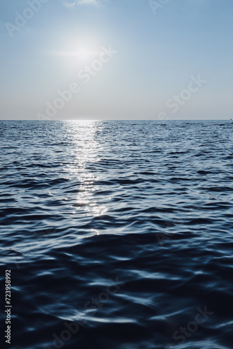 Fototapeta Naklejka Na Ścianę i Meble -  beautiful seascape. The blue sea goes into the horizon. reflection of the sun in the sea.vertical photo of the sea