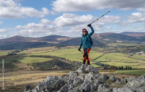 Cheerful smiling woman climber on top of the Great Sugarloaf mountain in Wicklow Ireland