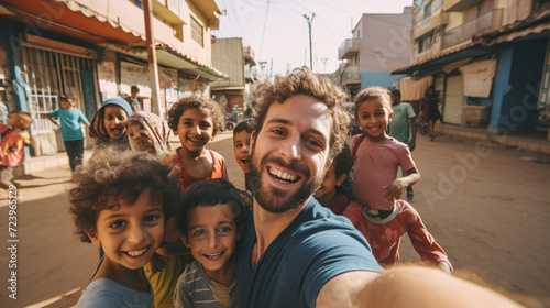 Smiling man taking a selfie with kids / children in the middle east on the playground.