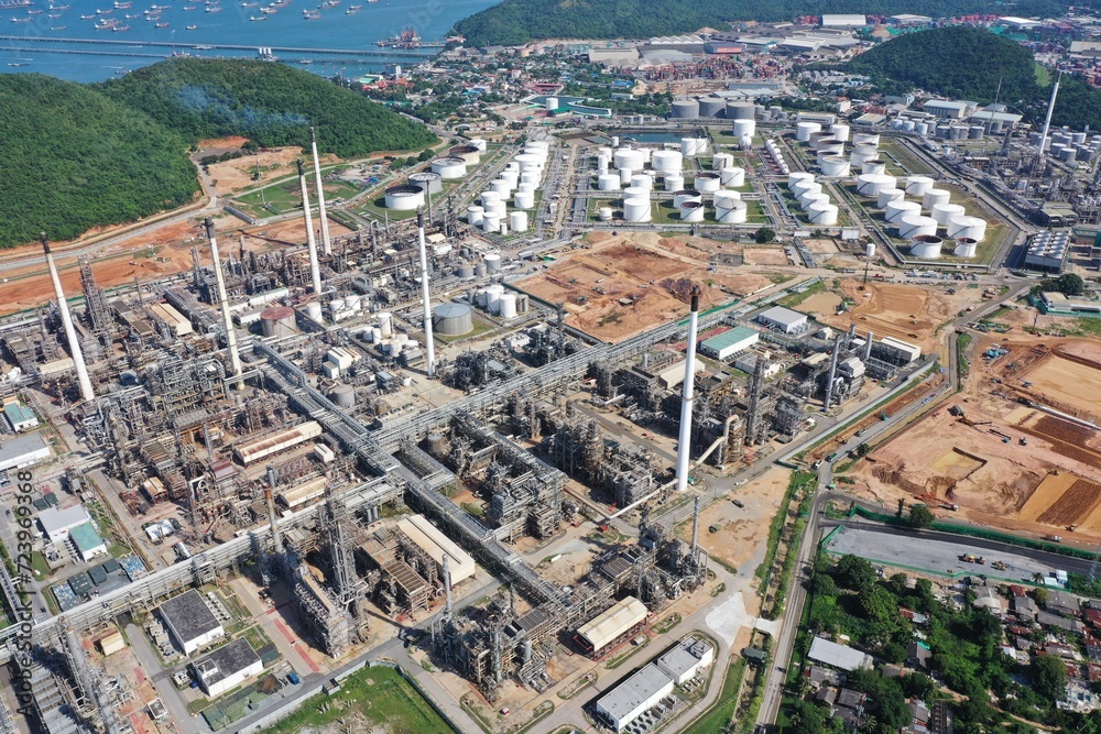 Aerial view of oil refinery or chemical factory and power plant with many storage tanks and pipelines. Business and petrochemical plants, oil storage tanks and for energy and steel pipes.