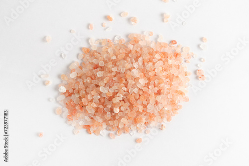 Crystals of pink edible Himalayan salt on a white background.