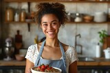 Smiling woman holding bowl of porridge and standing in kitchen at home