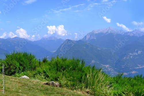 beautiful mountain landscape, green hills above Lake Como in Italy, mountains against backdrop of blue sky, concept of tourist season, outdoor adventure