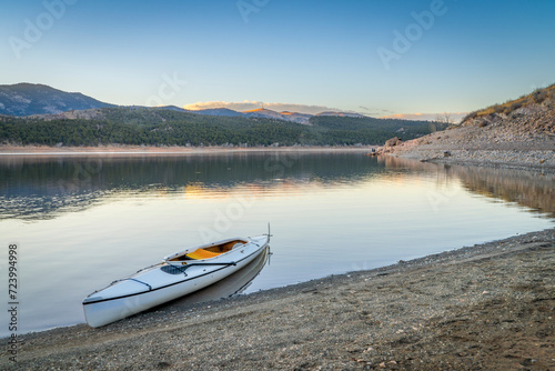 Fotografija expedition canoe on a shore of Carter Lake in northern Colorado, warm winter aft