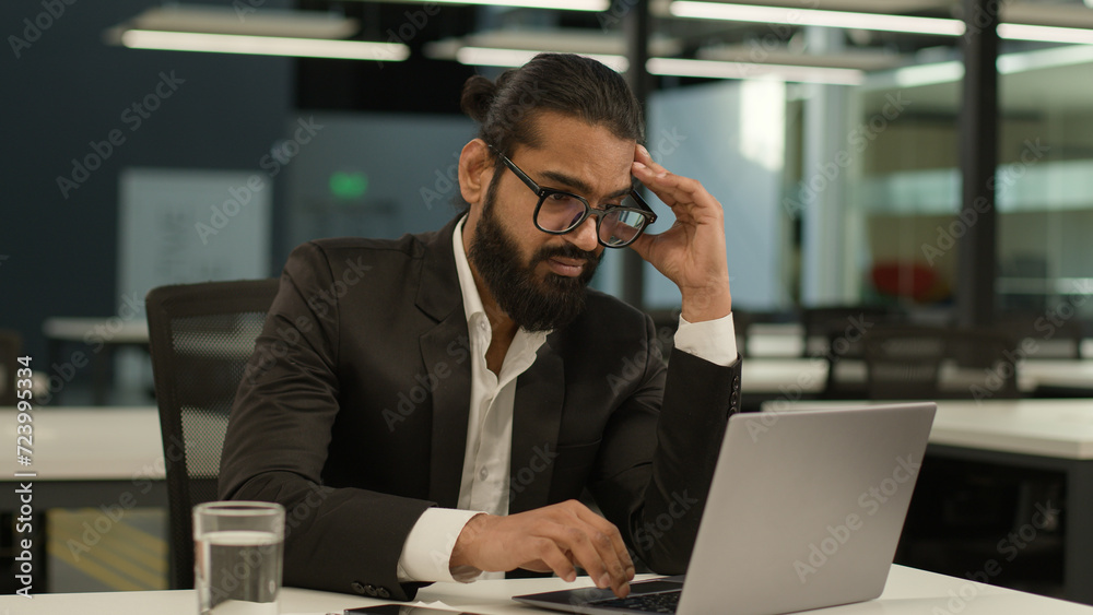 Bored Arabian business man at office table tired Indian clerk businessman worker sad dissatisfied disinterest manager employer boredom at workplace indoors laptop computer typing exhausted boring job Bored Arabian business man at office table tired Indian clerk businessman worker sad dissatisfied disinterest manager employer boredom at workplace indoors laptop computer typing exhausted boring job