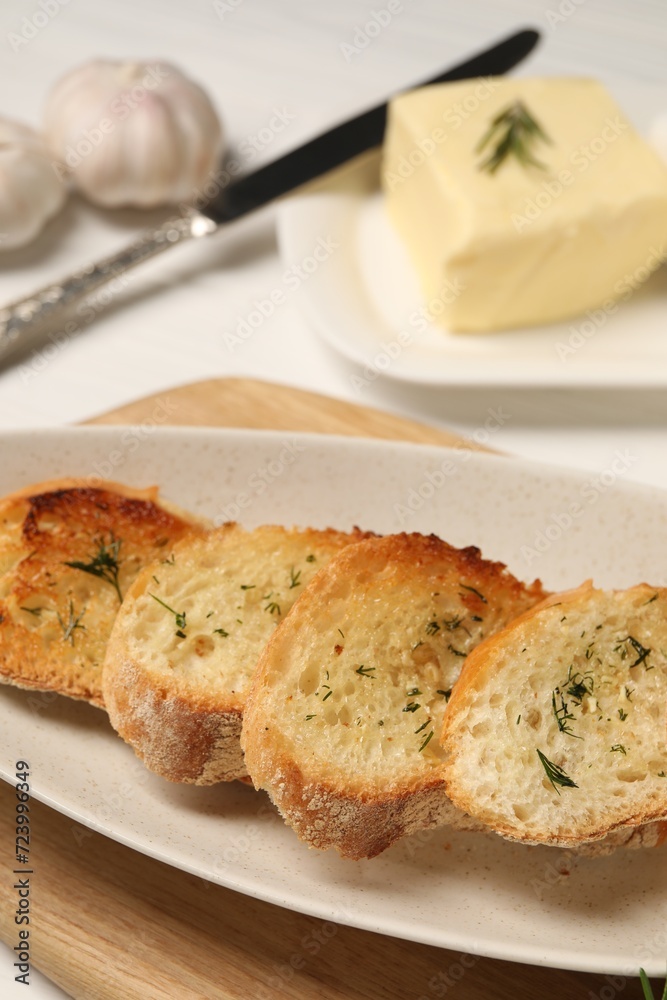 Tasty baguette with garlic and dill on table, closeup