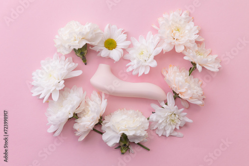 Fototapeta Naklejka Na Ścianę i Meble -  Concept erotic sex toy for female. Vacuum vibrator on pink background with flowers, flat lay
