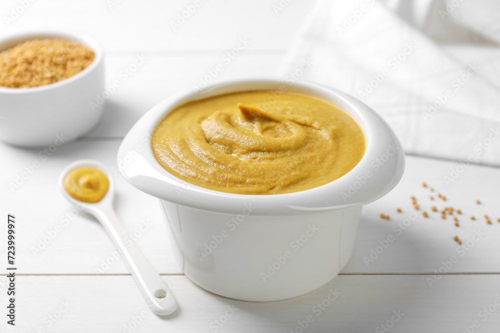 Tasty mustard sauce in bowl on white wooden table, closeup Tasty mustard sauce in bowl on white wooden table, closeup