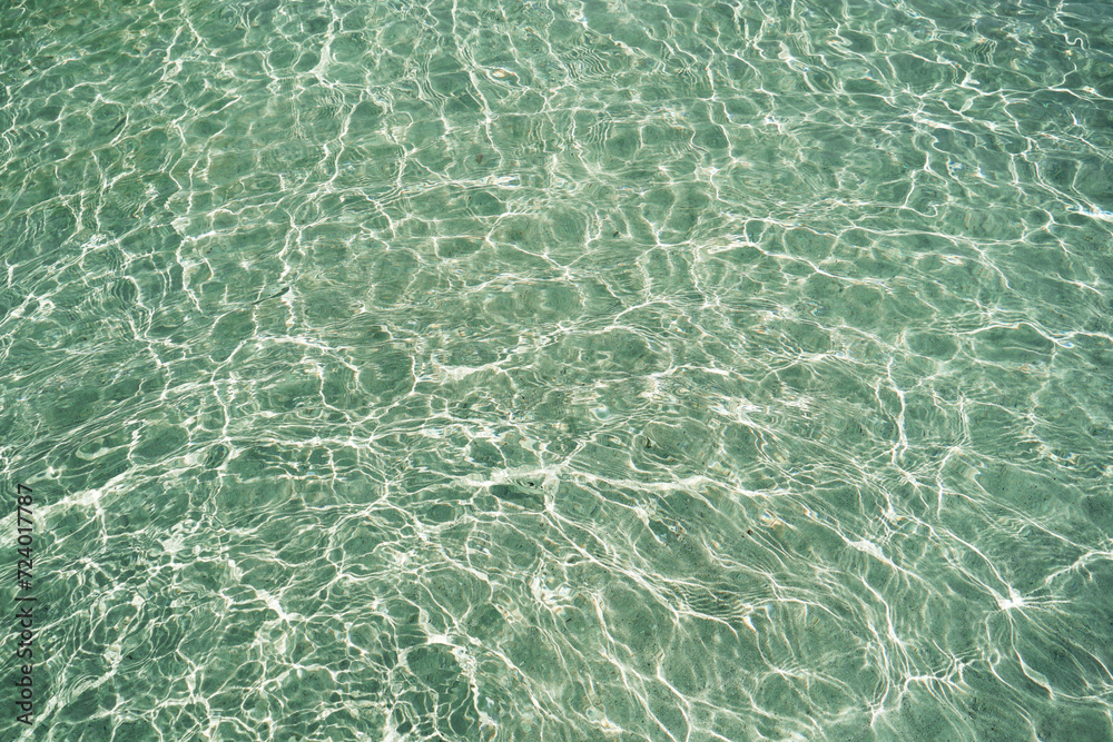 Detail of a sunlight reflecting in glittering sea. sparkler in water background. sea water with sun glare and ripple. Powerful and peaceful nature concept. Sea water surface background