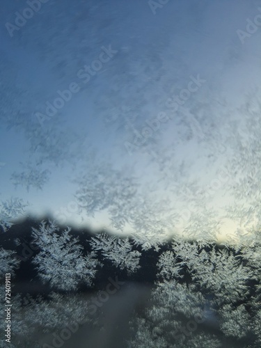 Ice crystals formations on glass car window.