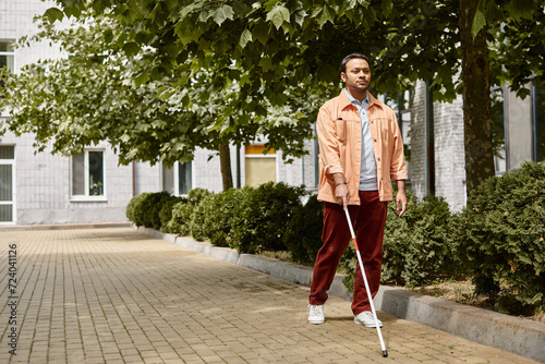 Εκτύπωση καμβά good looking indian man with blindness in orange vivid jacket with walking stick
