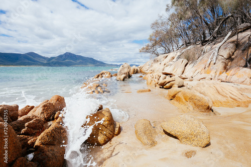 Une vague s'écrasant sur une plage de rochers en Tasmanie