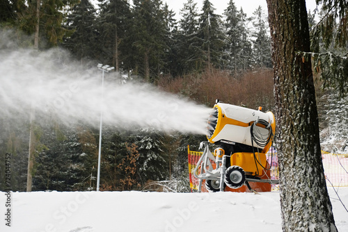 Snow cannon makes artificial snow. Snowmaking systems sprays water to produce snow.