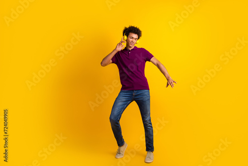 Photo of optimistic cheerful man dj wear trendy polo listen hit melody enjoy playlist isolated on yellow color background