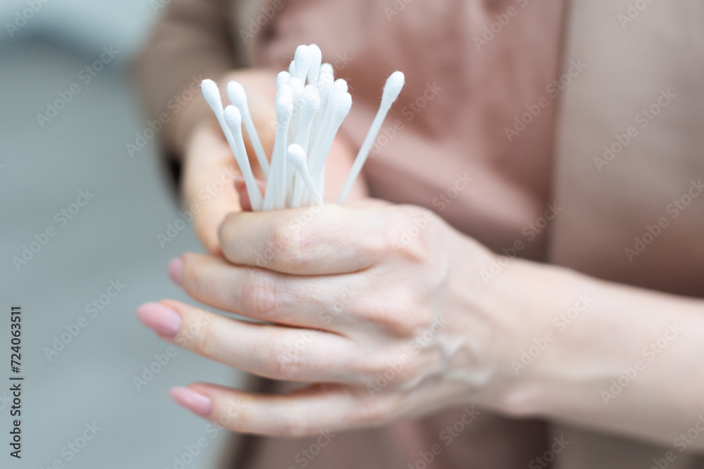 Cotton buds in hand isolated on white background. - obrazy, fototapety, plakaty 