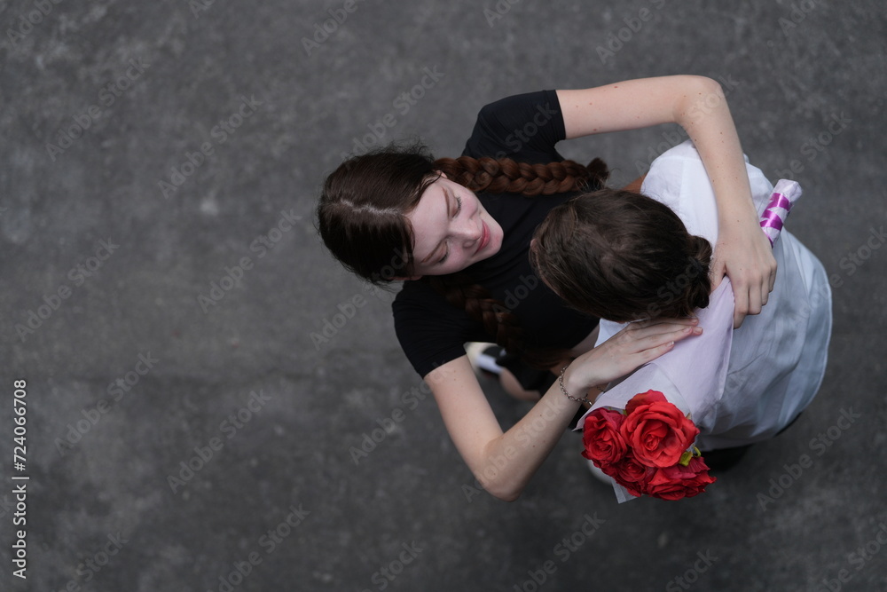 top aerial view of couple young man and woman hugging and holding the red bouquet rose flowers at outdoor street. Concept couple life with love and happy moment.