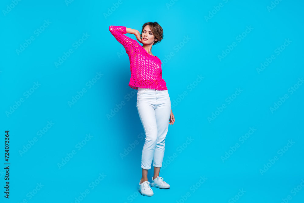 Full length photo of cheerful lovely woman wear knitted neon shirt looking empty space isolated blue color background Full length photo of cheerful lovely woman wear knitted neon shirt looking empty space isolated blue color background