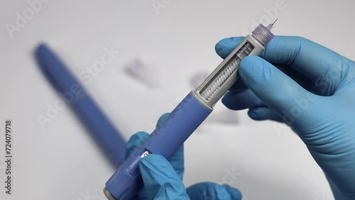 Hands in examination gloves demonstrate an injection with insulin for diabetics. photo