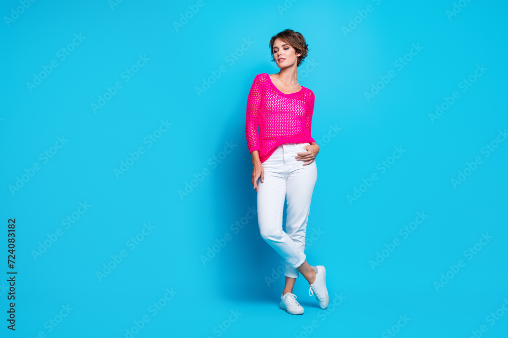 Full length photo of pretty shiny woman wear knitted neon shirt walking empty space isolated blue color background Full length photo of pretty shiny woman wear knitted neon shirt walking empty space isolated blue color background