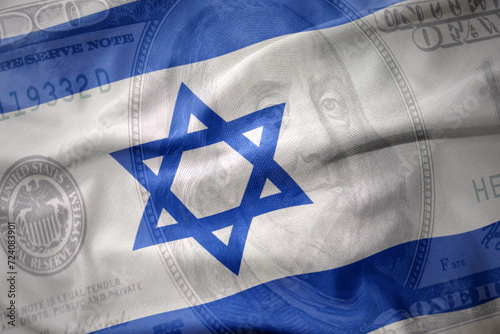 waving national flag of israel on a american dollar money background. finance concept. photo