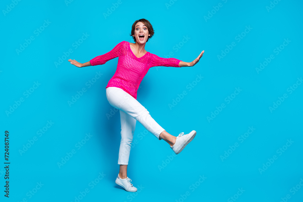 Full length photo of pretty impressed woman wear knitted neon shirt walking having disco fun empty space isolated blue color background