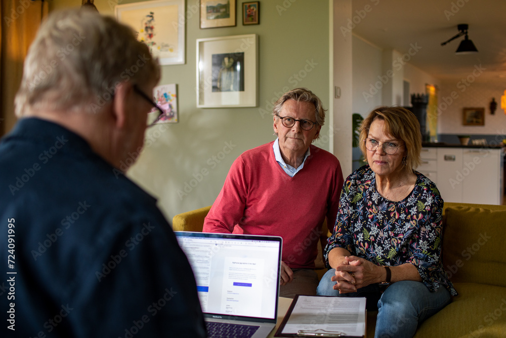 Worried senior couple talking to their financial advisor at home Worried senior couple talking to their financial advisor at home