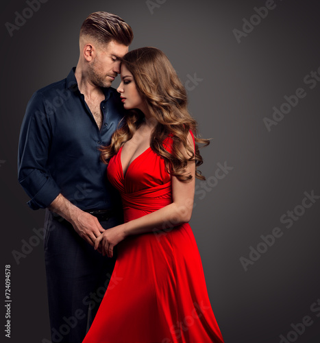 Couple Embracing in Love. Sexy Woman and Handsome Man in Romantic Hug over Gray. Lady in Red Dress with Boyfriend