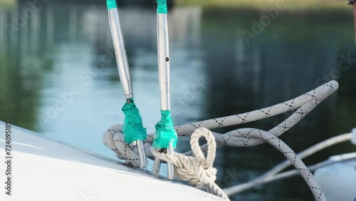 Adept yachtsman deftly fastens mooring rope to yacht. Professional man ensures sailboat secure anchorage in local harbor photo