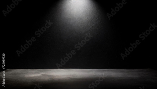 A spotlight illuminates an empty black room  providing a perfect background for text or presentations. The top lamp creates a reflective effect.