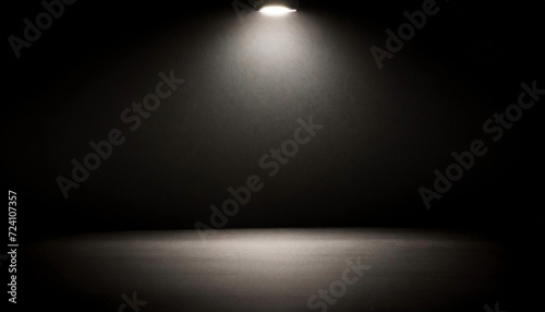 A spotlight highlights an empty room, offering a black canvas for text or presentations. The top lamp's light reflects, enhancing the overall ambiance.