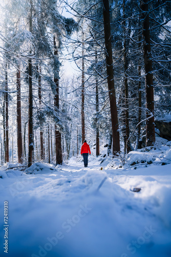 Wandern im Winter bei Schnee mit Frau und roter Jacke