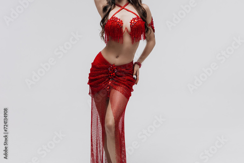 The part of body, Legs of a Female Dancer. Oriental belly dance girl in national red dress. Stunning female body. Foot movement in oriental dance. Elegant skirt beautifully spinning in the dance photo