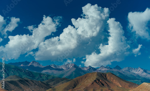 Picturesque landscape with mountains peaks and clouds