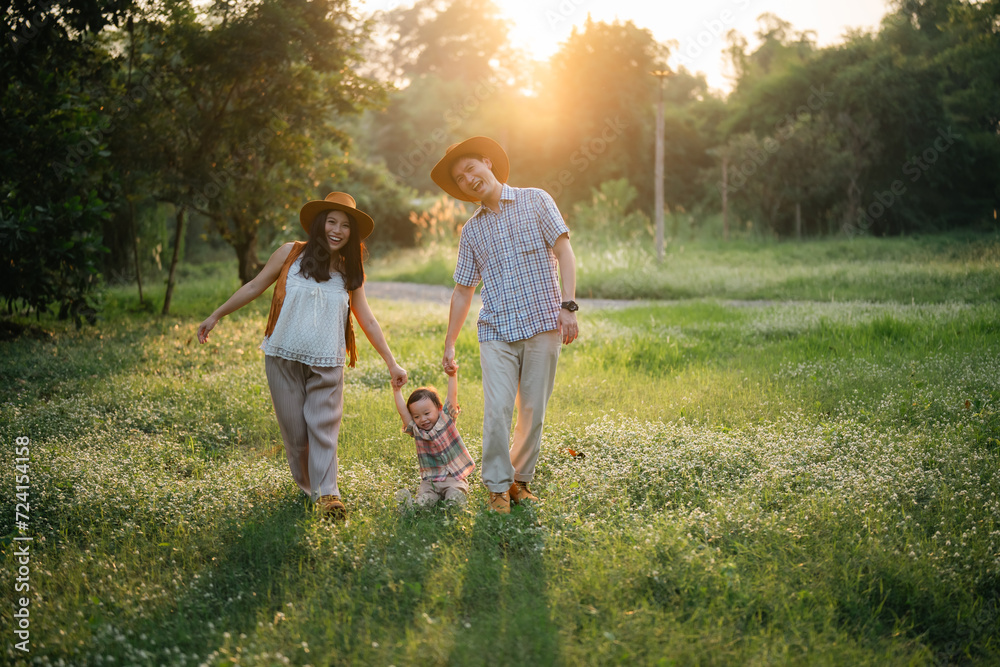 Fototapeta premium happy harmonious Asian family outdoors concept, Asian mother and son have activities happy fun together on holidays, grass land with sunlight