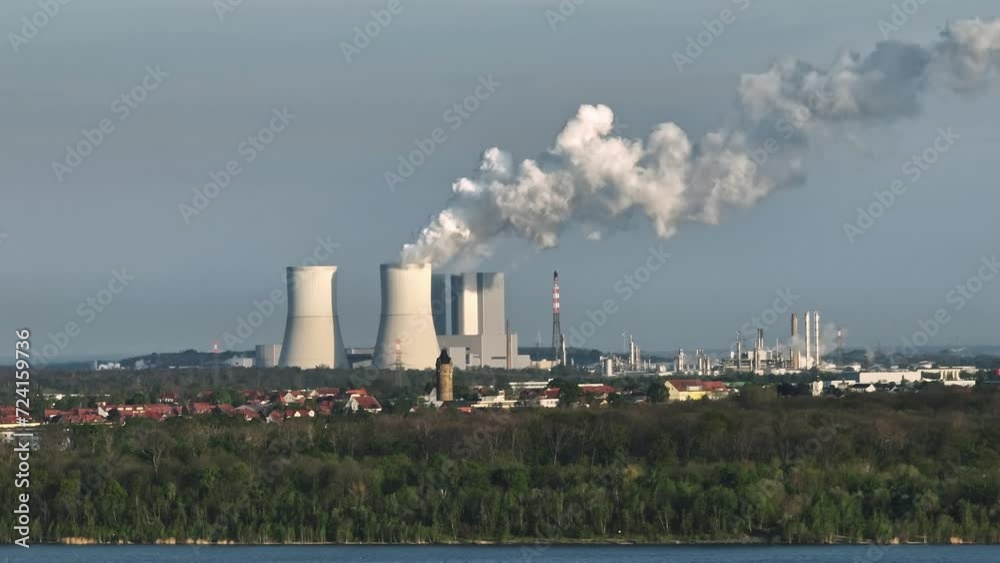 View from Zwenkau towards Böhlen and Lippendorf. The coal-fired power plant dominates the landscape. Steam rises from a cooling tower. The small town of Zwenkau and the Zwenkau lake in the foreground. View from Zwenkau towards Böhlen and Lippendorf. The coal-fired power plant dominates the landscape. Steam rises from a cooling tower. The small town of Zwenkau and the Zwenkau lake in the foreground.
