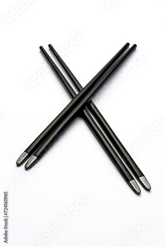 Black chopsticks resting on a white surface. Versatile image suitable for food, cooking, Asian culture, and dining themes