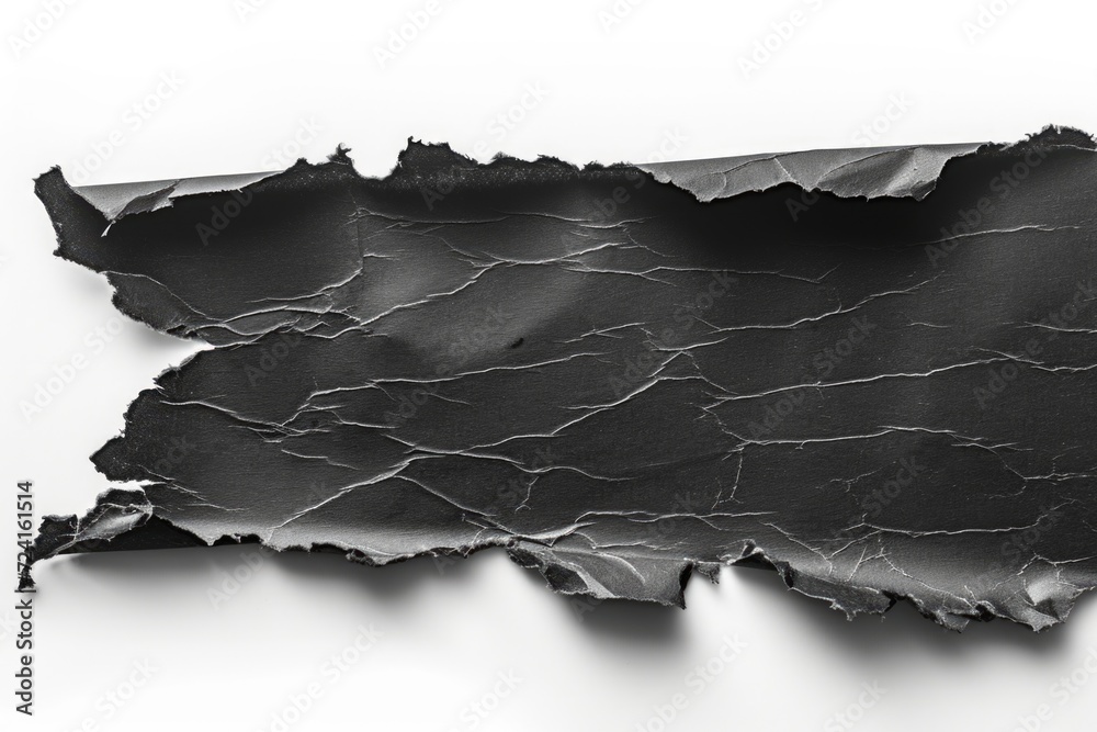 A torn piece of black paper on a white surface. Suitable for various graphic design projects