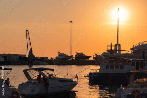 Yachts and boats moored at the seaport against a colorful sunset. The seaport of Sochi.  © Anastasiia Soina