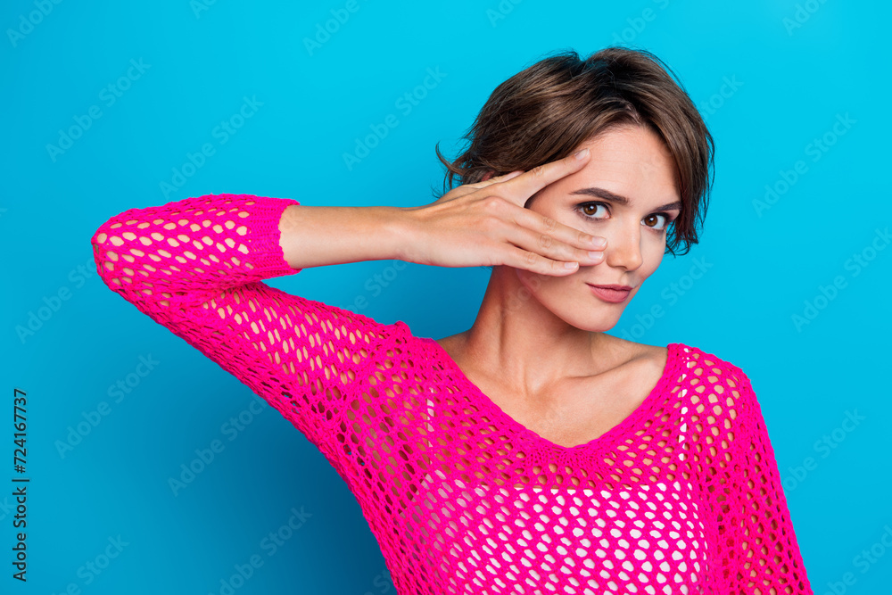 Photo of seductive cute woman wear knitted neon shirt hand cover eye smiling isolated blue color background Photo of seductive cute woman wear knitted neon shirt hand cover eye smiling isolated blue color background