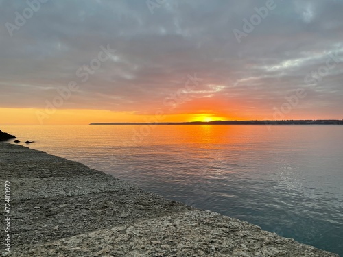 Cornish sunset over the sea at Polkerris photo