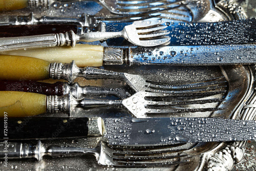 Fototapeta premium Antique silver cutlery on a dark background in a composition on a table.