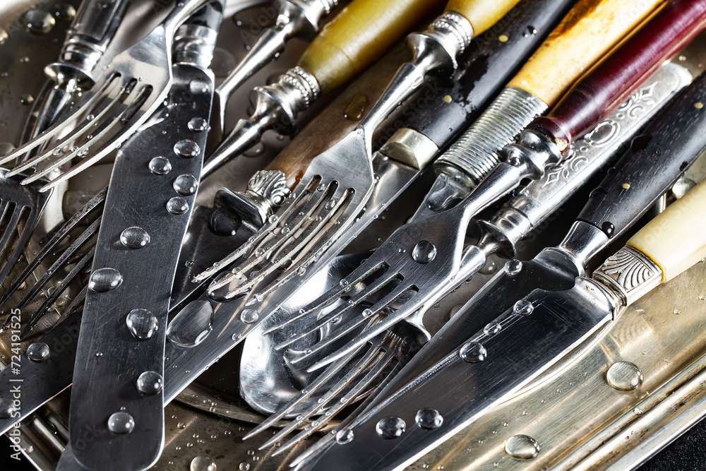 Fototapeta premium Antique silver cutlery on a dark background in a composition on a table.