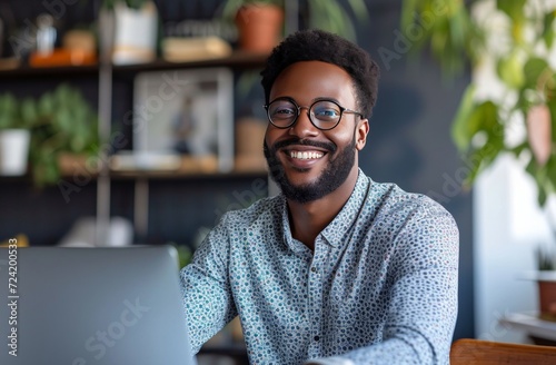 a man smiles sitting at his table using a computer