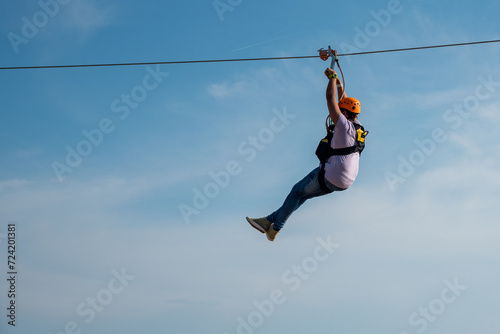 Obraz na plátně Zipline riders, Person on blue sky background, extreme leisure
