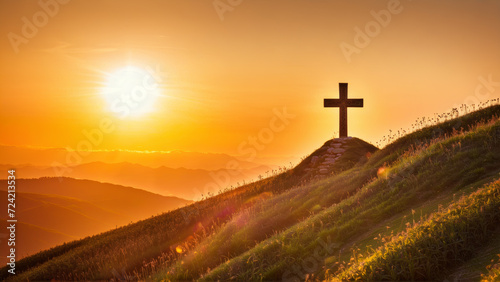 A photo of a cross standing on a hill as the sun sets in the background