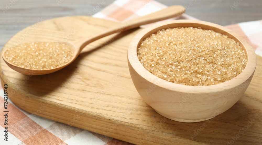 Brown sugar in bowl and spoon on table, closeup Brown sugar in bowl and spoon on table, closeup