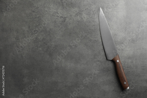 One knife on grey textured table, top view. Space for text